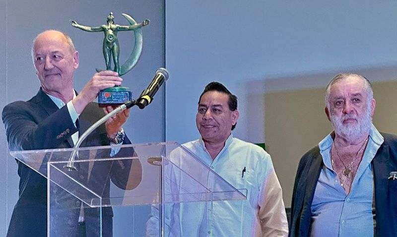 Trotti recibe el premio de manos del presidente del Foro Nacional de Periodistas, Rafael Cano. Junto a ellos, a la derecha, el presidente de la Asociación Mexicana de Editores, Gonzalo Leaño.