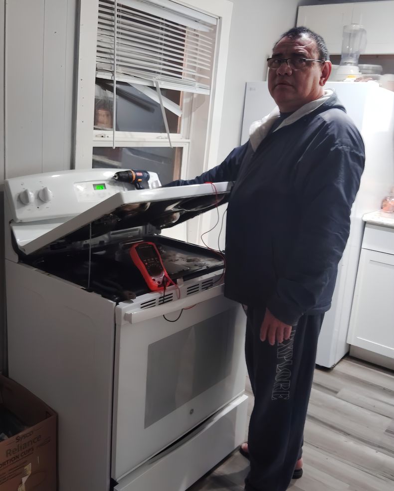 Johnny Balmaceda repara una cocina eléctrica. Aprovecha sus conocimientos en electrónica para desempeñarse como técnico en los Estados Unidos, donde emigró tras salir de Costa Rica. Cortesía.