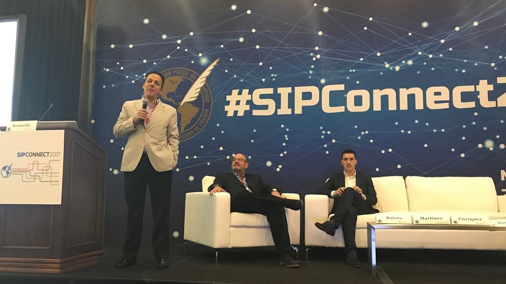 De pie, Marcos Enríquez, LowPost junto a sus compañeros de panel, Carlos Martínez, PressReader y Héctor Botero, ContenEngine.